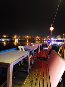 a row of tables and chairs on a dock at night at Brand new vacation house- Private gated community in Banda Aceh