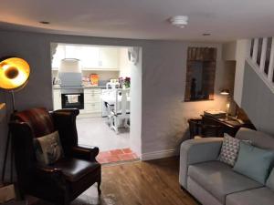 a living room with a couch and a kitchen at Arthur Street Guest Cottage No16 in Hillsborough