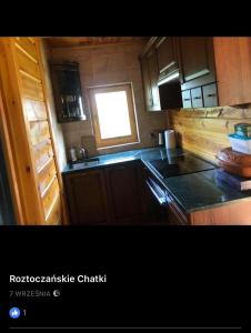 a small kitchen with a sink and a window at Roztoczańskie Chatki in Kaczórki