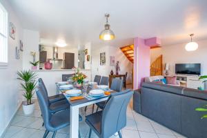 uma sala de jantar e sala de estar com mesa e cadeiras em Gîte La Villa Omagny Paris Marne-la-Vallée em Magny-le-Hongre