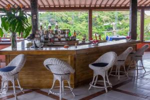 un bar con sillas de mimbre en un complejo en Colonna Galapagos Garden Hotel, en Búzios