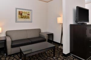 a living room with a couch and a tv at Holiday Inn Express & Suites Tacoma South - Lakewood, an IHG Hotel in Lakewood