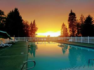 una piscina con tramonto sullo sfondo di Chehalis Camping Resort One-Bedroom Cabin 2 a Onalaska