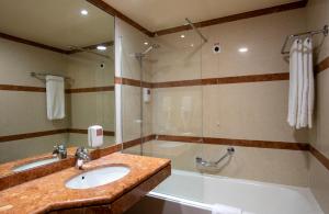 a bathroom with a sink and a shower at Monte Mar Palace Hotel in Ponta Delgada