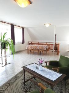 sala de estar con mesa y algunas sillas en Édenkert Apartman, en Keszthely