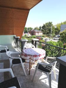 a patio with a table and chairs on a balcony at Édenkert Apartman in Keszthely