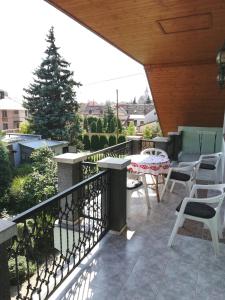 balkon z krzesłami, stołem i drzewem w obiekcie Édenkert Apartman w mieście Keszthely