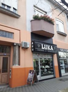 a store with a sign in front of a building at Apartman ANA in Slavonski Brod