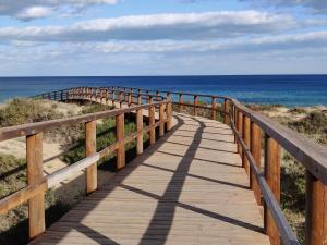 una passerella di legno che conduce all'oceano sulla spiaggia di Duna de arenales ad Arenales del Sol