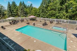 a swimming pool with chairs and tables and a fence at Chehalis Camping Resort Cottage 1 in Onalaska