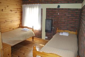 um quarto com 2 camas e uma parede de tijolos em Los Teros em Esquel