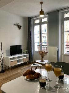 een woonkamer met een tafel met een bord eten bij Résidence Le Musoir in Le Tréport