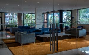 a lobby with blue couches and tables and windows at Monte Mar Palace Hotel in Ponta Delgada