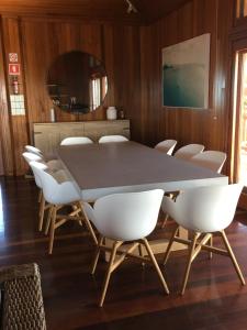 a dining room with a table and white chairs at Camp Island Lodge in Guthalungra