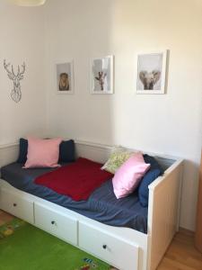 uma cama num quarto com almofadas cor-de-rosa e azuis em Über den Dächern des Kaßbergs em Chemnitz