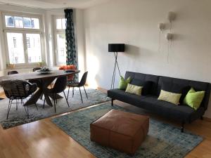 a living room with a black couch and a table at Über den Dächern des Kaßbergs in Chemnitz