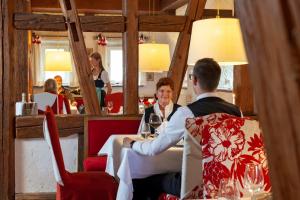 un hombre y una mujer sentados en una mesa en un restaurante en Romantik Hotel Johanniter-Kreuz, en Überlingen