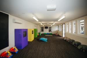 a hallway with a room with toys and a tv at Northstar Motel in Oamaru