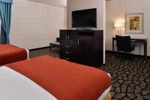 Holiday Inn Express & Suites Tacoma South - Lakewood, an IHG Hotel في ليكود: غرفة فندقية بسريرين وتلفزيون بشاشة مسطحة