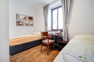 um quarto com uma secretária, uma cama e uma cadeira em Penzion Královská Cesta em Brno