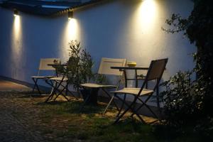 un grupo de sillas y una mesa frente a una pared en Pension zum Birnbaum en Brandenburg