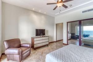 ein Schlafzimmer mit einem Bett, einem Stuhl und einem TV in der Unterkunft Vista las Palmas 10C in Jacó