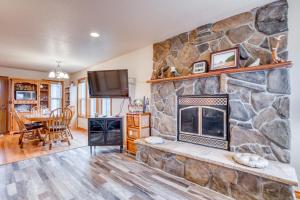 a living room with a stone fireplace and a tv at Spacious Seaside Home with an Ocean View in Seaside