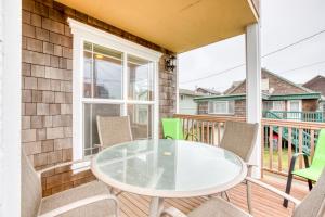 a patio with a glass table and chairs on a balcony at Spacious Seaside Home with an Ocean View in Seaside