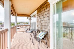 a balcony with chairs and a table and a window at Spacious Seaside Home with an Ocean View in Seaside