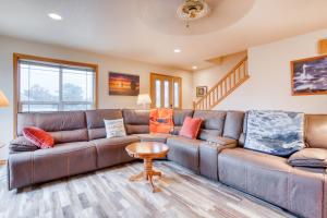 a living room with a brown leather couch at Spacious Seaside Home with an Ocean View in Seaside