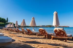 - une rangée de chaises et de parasols sur une plage dans l'établissement Kavouri beach house just 6 minutes walk to Kavouri beach, à Athènes