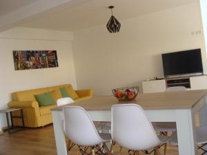 a living room with a dining room table with white chairs at Casa do Largo in Faro