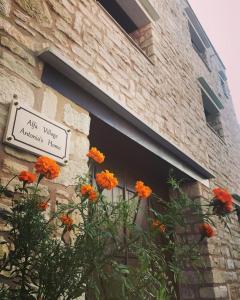 un edificio con fiori d'arancio davanti a una finestra di Antonia’s Home Alfa Village a Alfá