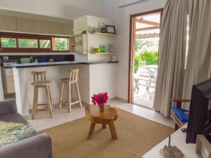 een woonkamer met een bank en een tafel met bloemen erop bij Luxury Villa - Madeiro in Pipa
