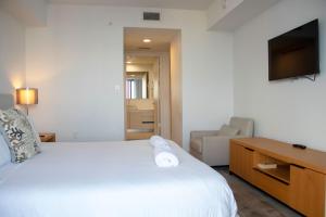une chambre d'hôtel avec un lit et une télévision dans l'établissement Beach Walk, à Hallandale Beach