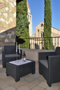 a patio with two chairs and a table with wine glasses at CASA VISTANTICA in Aquiléia