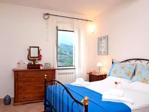 a bedroom with a blue and white bed and a window at Affittacamere Le Terrazze in Corniglia