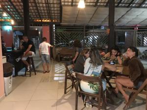 um grupo de pessoas sentadas numa mesa num restaurante em Pousada Toca do Ceará em Regência
