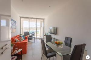 a kitchen and living room with a table and chairs at Sea View Apartment Mellieha in Mellieħa