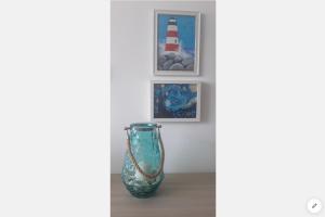 a vase sitting on a table next to a lighthouse at Sea View Apartment Mellieha in Mellieħa