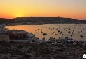 a group of boats in a harbor at sunset at Sea View Apartment Mellieha in Mellieħa