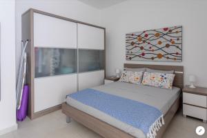 a bedroom with a bed and a painting on the wall at Sea View Apartment Mellieha in Mellieħa