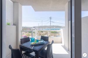 comedor con mesa, sillas y ventana en View Point Ghadira Melliha, en Mellieħa