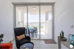 a living room with sliding glass doors leading to a dining room at Sea View Apartment Mellieha in Mellieħa