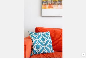 a couch with a pillow and a picture on the wall at Sea View Apartment Mellieha in Mellieħa