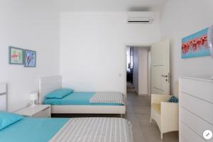 a small bedroom with two beds and a chair at Sea View Apartment Mellieha in Mellieħa