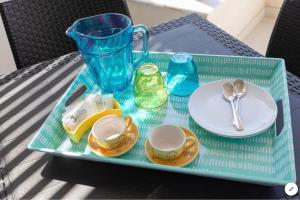 a blue tray with a plate and a vase on a table at Sea View Apartment Mellieha in Mellieħa
