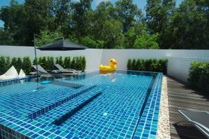 a swimming pool with a yellow rubber duck sitting on the edge of it at Happy Family Villa in Phuket Town