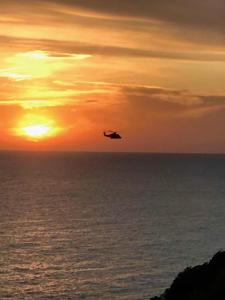 a plane flying over the ocean at sunset at Affittacamere Le Terrazze in Corniglia