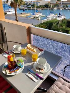 a table with food and drinks on top of a balcony at Cap Capistol Studio le Cap d'Agde vue port in Cap d'Agde